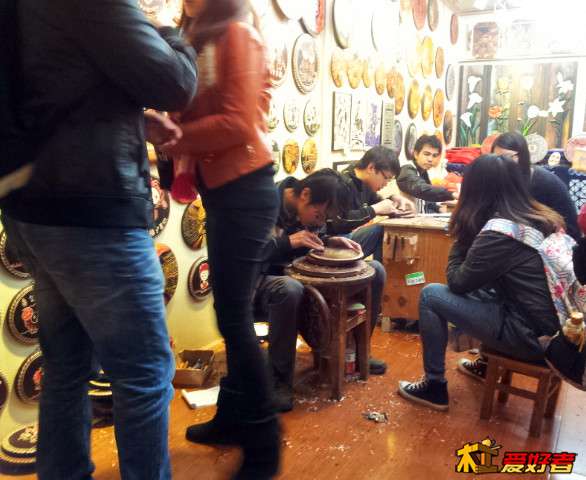 几个年轻的徒弟在为客人刻简单作品