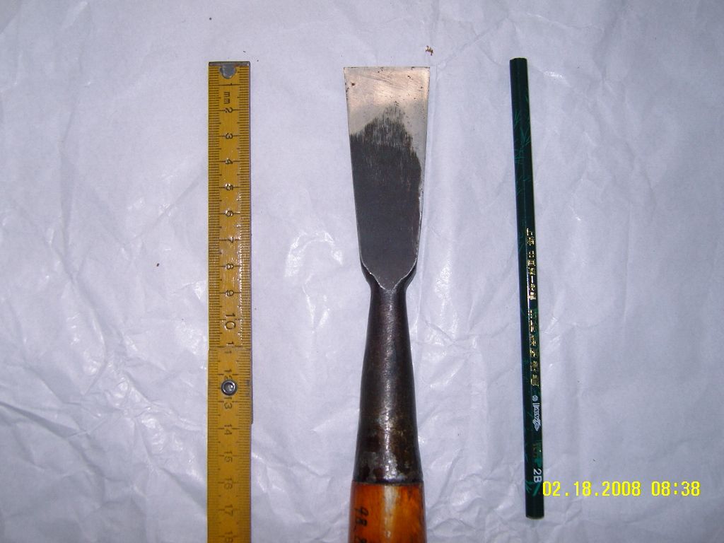 带肋筋的扁铲，头短厚实，柄部装箍，适合锤子击打。